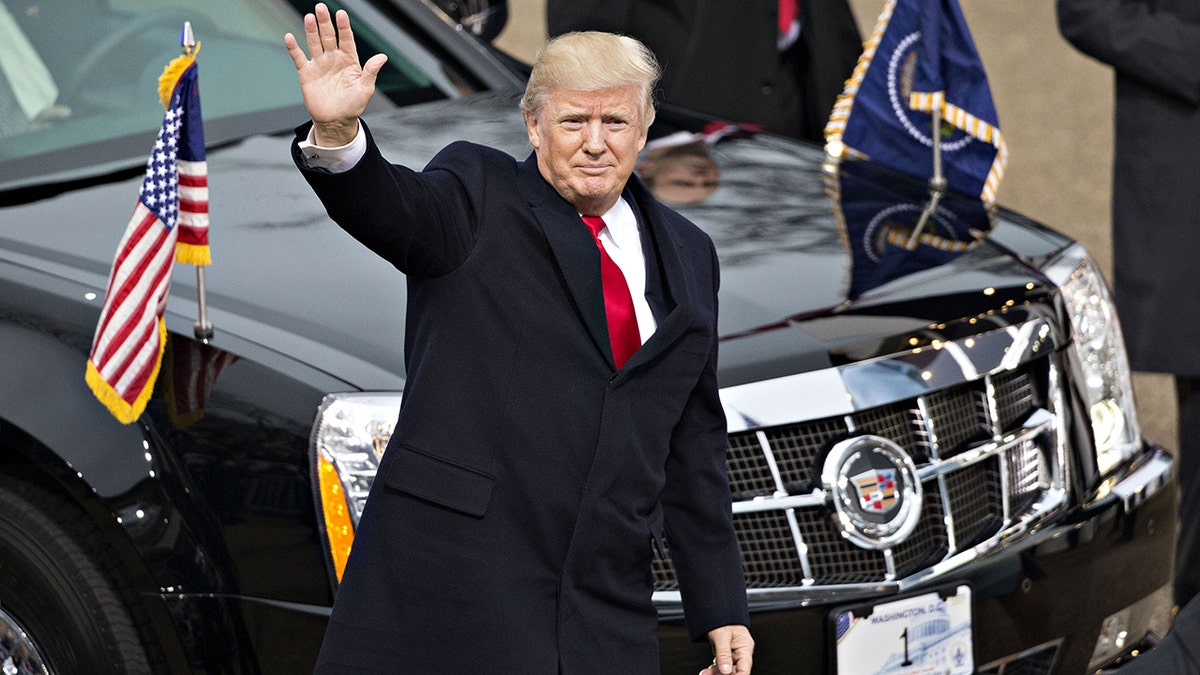 President Donald Trump waves in front of his motorcade