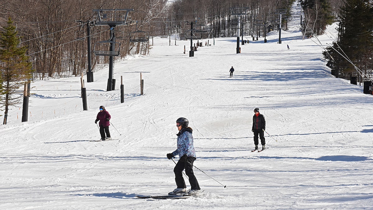 Skiers make their way down the slope at Jiminy Peak Mountain Resort