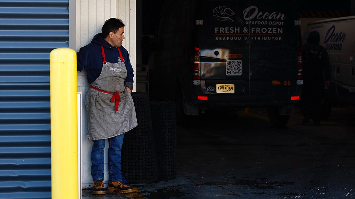 An employee stands outside the Ocean Seafood Depot where ICE conducted a raid