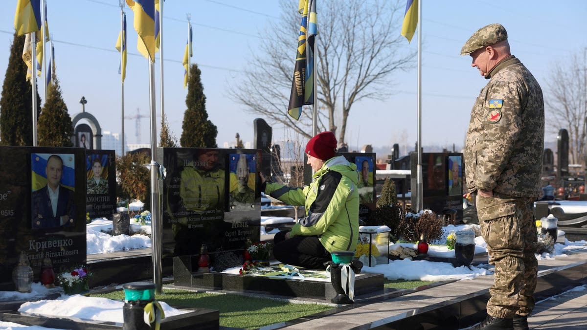 A woman and a man visit a memorial commemorating the anniversary of the war in Ukraine