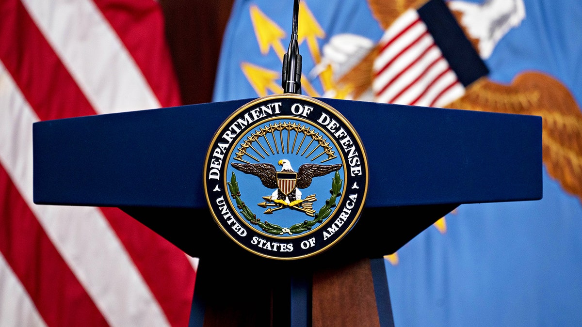 DOD lectern with flags behind it