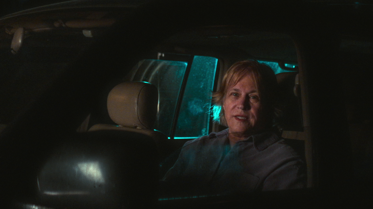 Jill Shiveley is seated in the driver's seat of a motor vehicle while speaking to an interviewer at nighttime