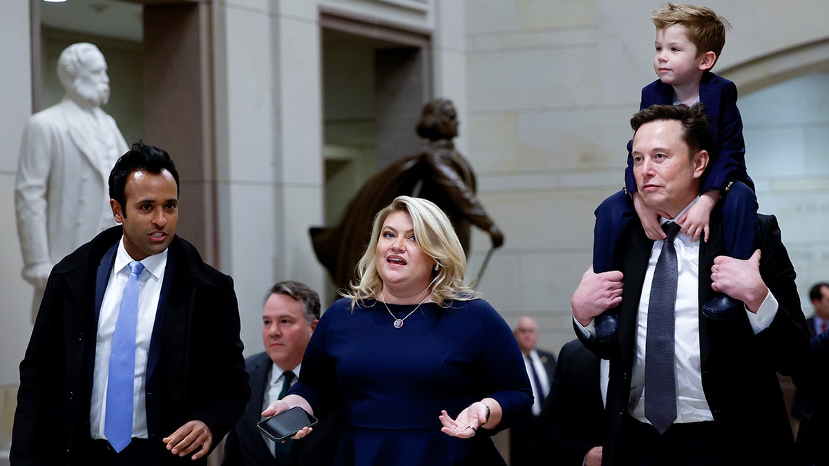 Vivek Ramaswamy, Rep. Kat Cammack, and Elon Musk carrying one of his children on his shoulders