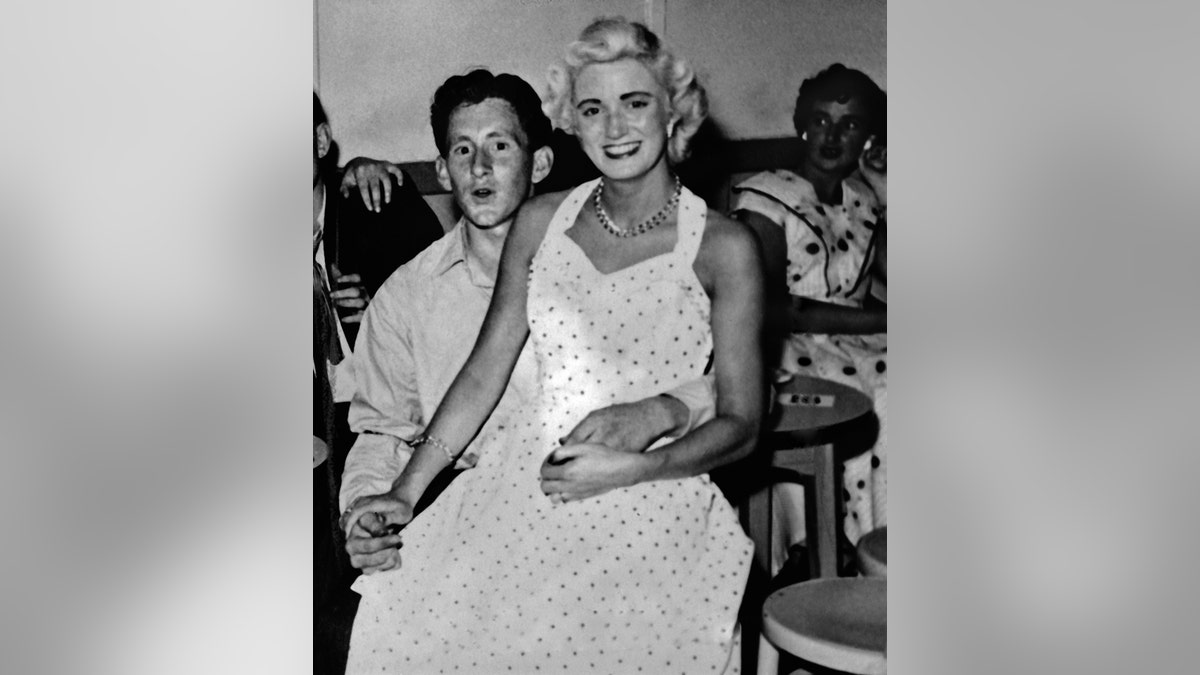 Ruth Ellis sitting on a man's lap.