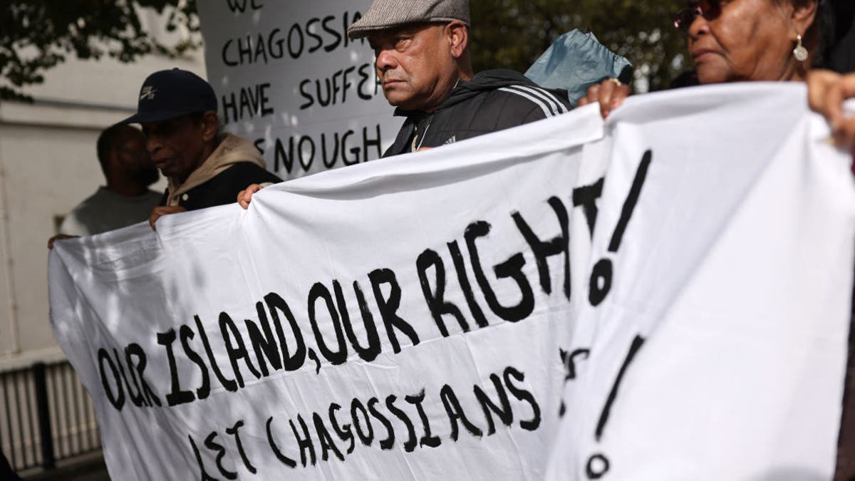 Members of the Chagossian community gather outside parliament to protest