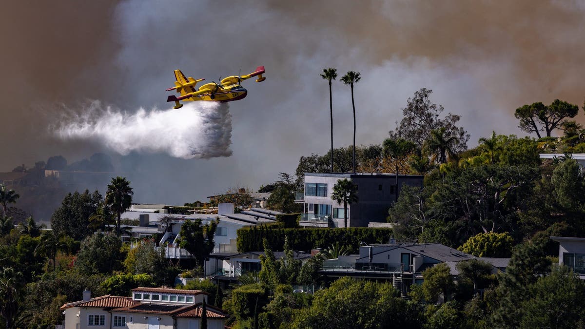 plane drops water on palisades fire