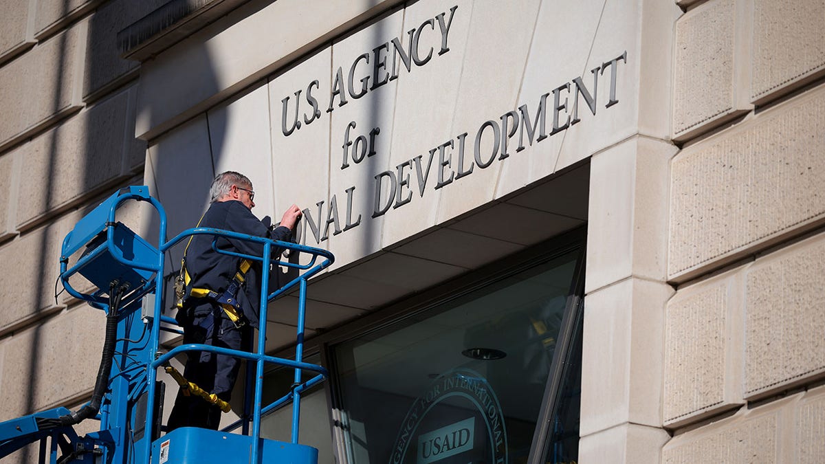 USAID building sign being removed