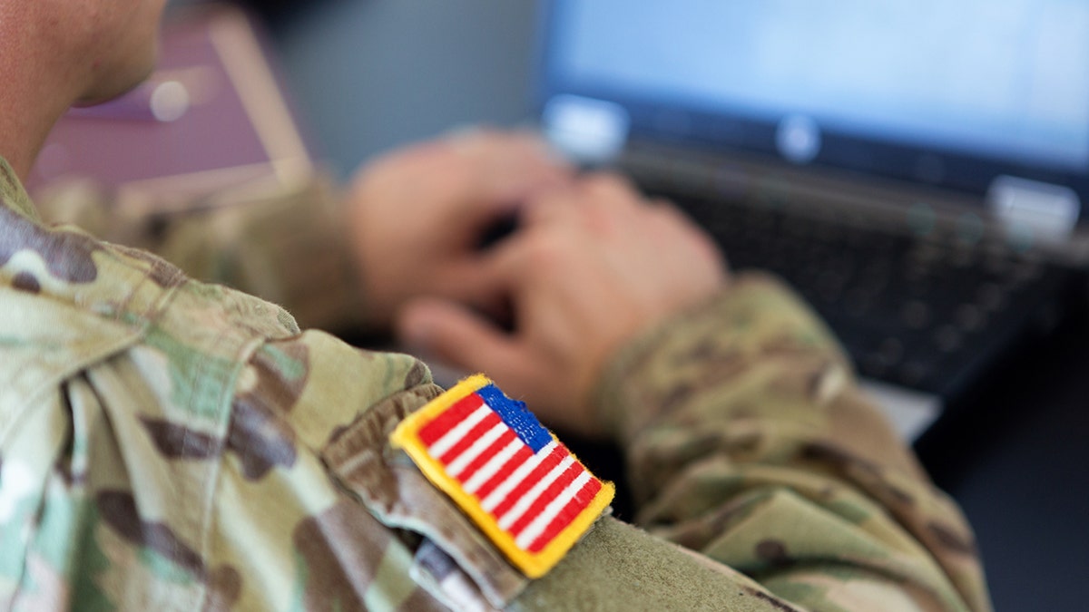 closeup shot of service member in BDU with US flag patch