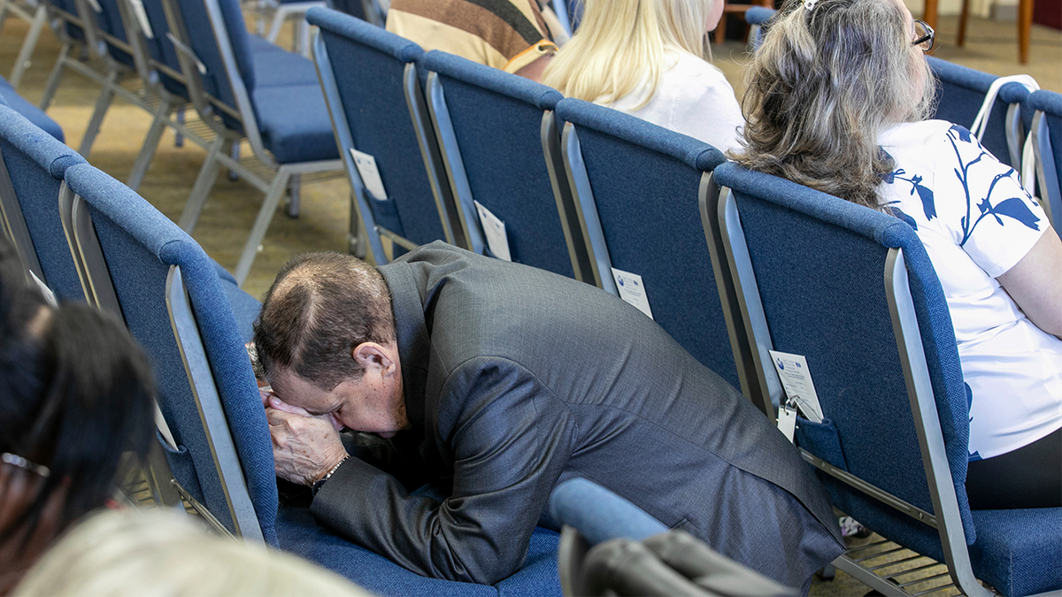 A congregant kneels in prayer