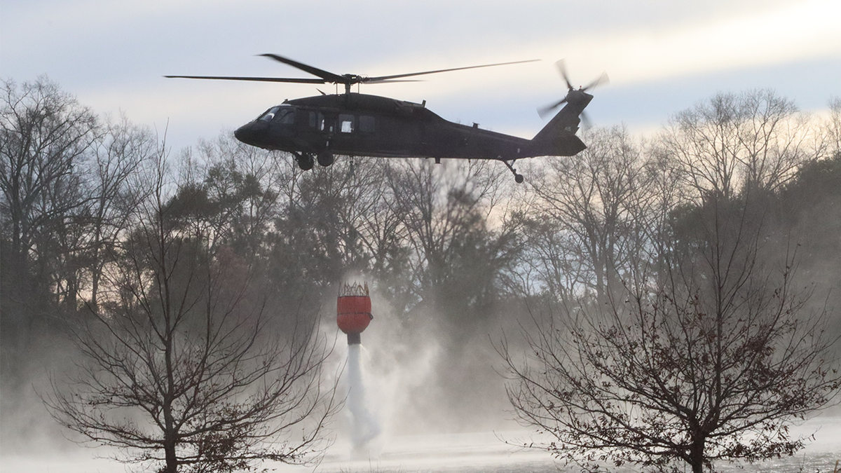 A Black Hawk scoops up water