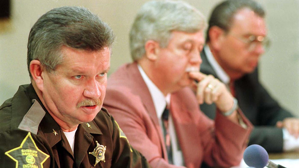 Police sitting next to each other at a press conference.