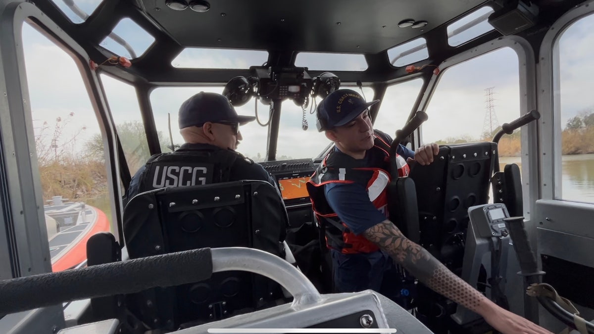 Two men in a U.S. Coast Guard patrolling the Rio Grande